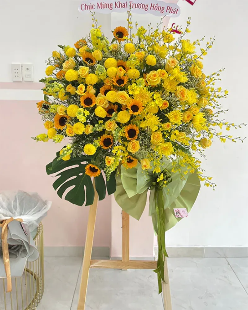 Một bó hoa hướng dương tươi tắn cắm trong bình, thể hiện ý nghĩa lạc quan, hy vọng